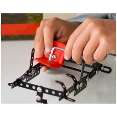 Hands assembling the Alexander Constructor Black Spider set with red plastic and black metal pieces.