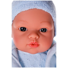 Lifelike Koke doll with blue eyes and knitted blue hat, showcasing realistic features and rosy cheeks.