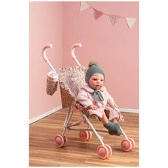 Martina Collection doll stroller with pink wheels, floral fabric, and foam handles, holding a doll in a pink outfit.