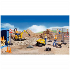 Construction play scene with toy figures, yellow digger, JCB truck, safety barriers, and tools on gravel under a blue sky.