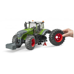 Hand demonstrating removable wheel on green Bruder Fendt 1050 Vario toy tractor with red rims.