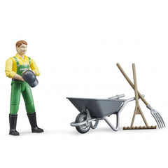 Farmer figure in green overalls with a wheelbarrow, pitchfork, and besom set for imaginative farm play.