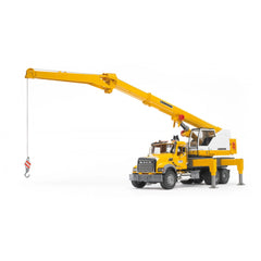 Yellow Bruder MACK Granite Liebherr crane truck toy with extendable boom and stabilizing support legs on white background.