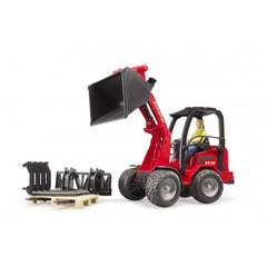 Red Bruder Schäffer Compact Loader 2630 with movable arm, figure in driver's seat, and black accessories on beige pallet.