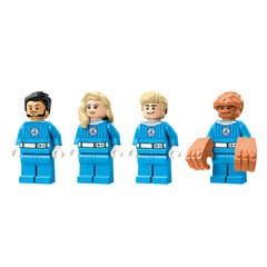 Four LEGO minifigures from the Fantastic Four, each wearing blue suits with the number 4. From left to right: Mr. Fantastic with black hair, Invisible Woman with blonde hair, Human Torch with blonde hair, and The Thing with brown rocky skin.