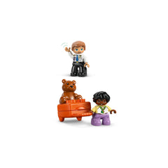 Two LEGO DUPLO figures, one wearing a pilot uniform waving, and the other holding a suitcase with a bear.