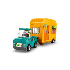 A vibrant teal car with a minifigure driving, towing an orange caravan adorned with green accents and large windows.