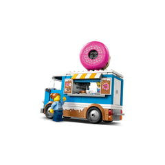Colorful LEGO City Donut Truck with a giant pink donut on top, featuring a service window and minifigure serving a customer.
