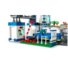 LEGO City Police Station set featuring a blue police car parked outside, a red and white barrier, and a character at the window.