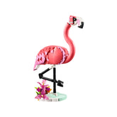 Colorful LEGO Creator 3in1 pink flamingo construction set, posed on one leg, surrounded by vibrant plant elements on a white background.