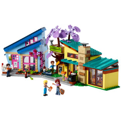 Colorful LEGO Friends construction set featuring two houses and a tree house, with five mini-dolls and two pets interacting outside.