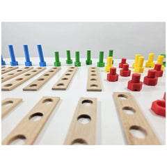 Wooden planks with holes, colorful plastic screws and connectors in blue, green, red, and yellow on a white surface.