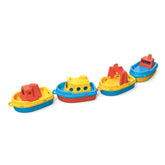 Four colorful plastic boats, red and yellow, in a line; ferry, passenger, tugboat, cargo ship.