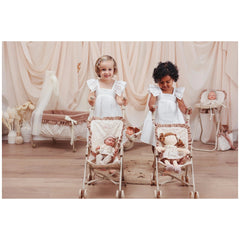 ASI Dolls Dreams Stroller featuring two smiling children in vintage baby carriages against a softly lit pastel background.