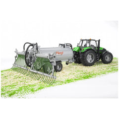 Bruder Fliegl Barrel Trailer with green tractor on textured surface, featuring realistic details and spread tubes.