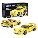 CaDA Initial D Mazda RX-7 FD3S yellow toy car features black wheels, roof, spoiler, and bumpers, displayed in black packaging