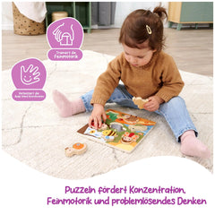 A child in a brown sweater and blue jeans sits on a white rug, intently reading a colorful childrens book.