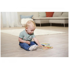 Eichhorn wooden drum and xylophone music set displayed with a child engaged in play on a wooden floor in a cozy room.
