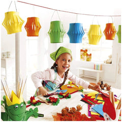 Folia Creative Box features a young girl in a green apron at a white table with colorful paper, yellow pencils, and wooden-ha