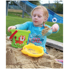 Gowi beach bucket in a lifestyle scene with a young girl in blue top, holding a yellow shovel, surrounded by sand toys.