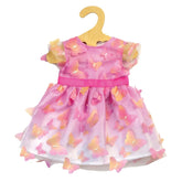 Heless Miss Butterfly dress for dolls, pink with white lining, adorned with pink and yellow butterflies, displayed on a woode