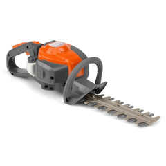Husqvarna toy hedge trimmer with orange plastic casing, black handle, gray metal blade, and gray plastic guide in front view.