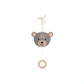 Brown knitted teddy bear hanging from a wooden ring by a string, featuring a lighter face, paws, and black eyes.