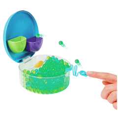 Orbeez Water Beads Surprise Activity Orb Set features a hand pointing at a bowl filled with green and yellow translucent bead
