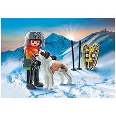 PLAYMOBIL Hiker with Saint Bernard in snowy landscape, featuring Lego figures, skis, and a blue gradient sky.