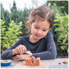 Teifoc creative box with 145 pieces is showcased as a young girl joyfully engages in arts and crafts at a wooden table.