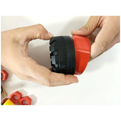 Hands assembling a black and red plastic part from the Alexander Maly Constructor Junior construction set.