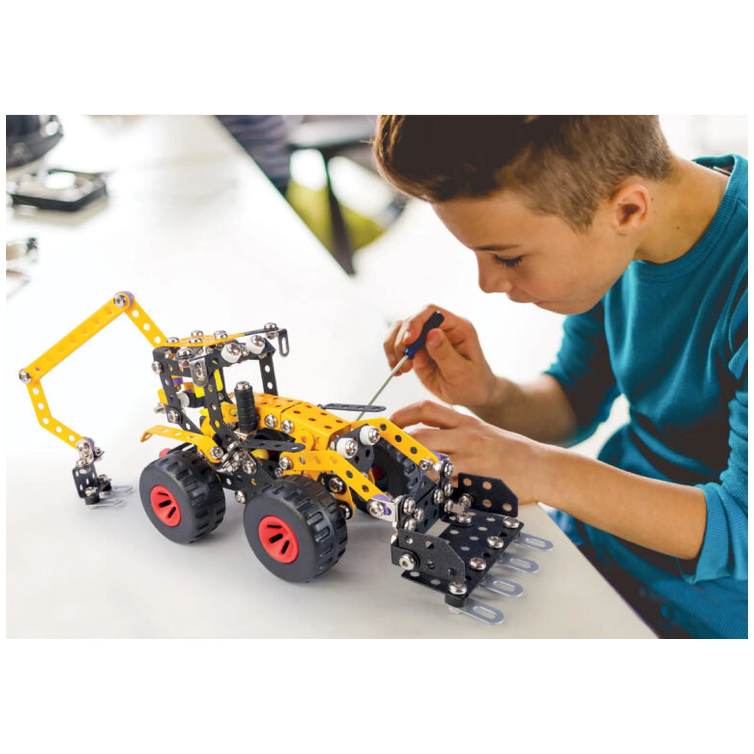 Child assembling a yellow and black construction vehicle model with wheels from the Alexander 5-in-1 construction set.