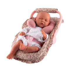 Doll in floral fabric pram with pink neck cushion, wearing white onesie, seated in Maxi-Cosi from Asi Dolls' Martina Collection.