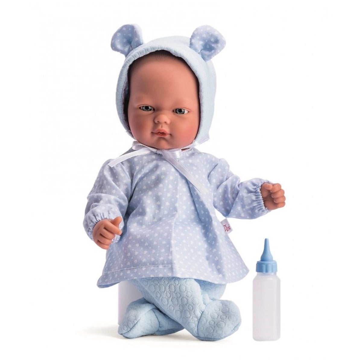 Lifelike baby doll in blue polka dot outfit and bonnet, sitting with bottle beside.