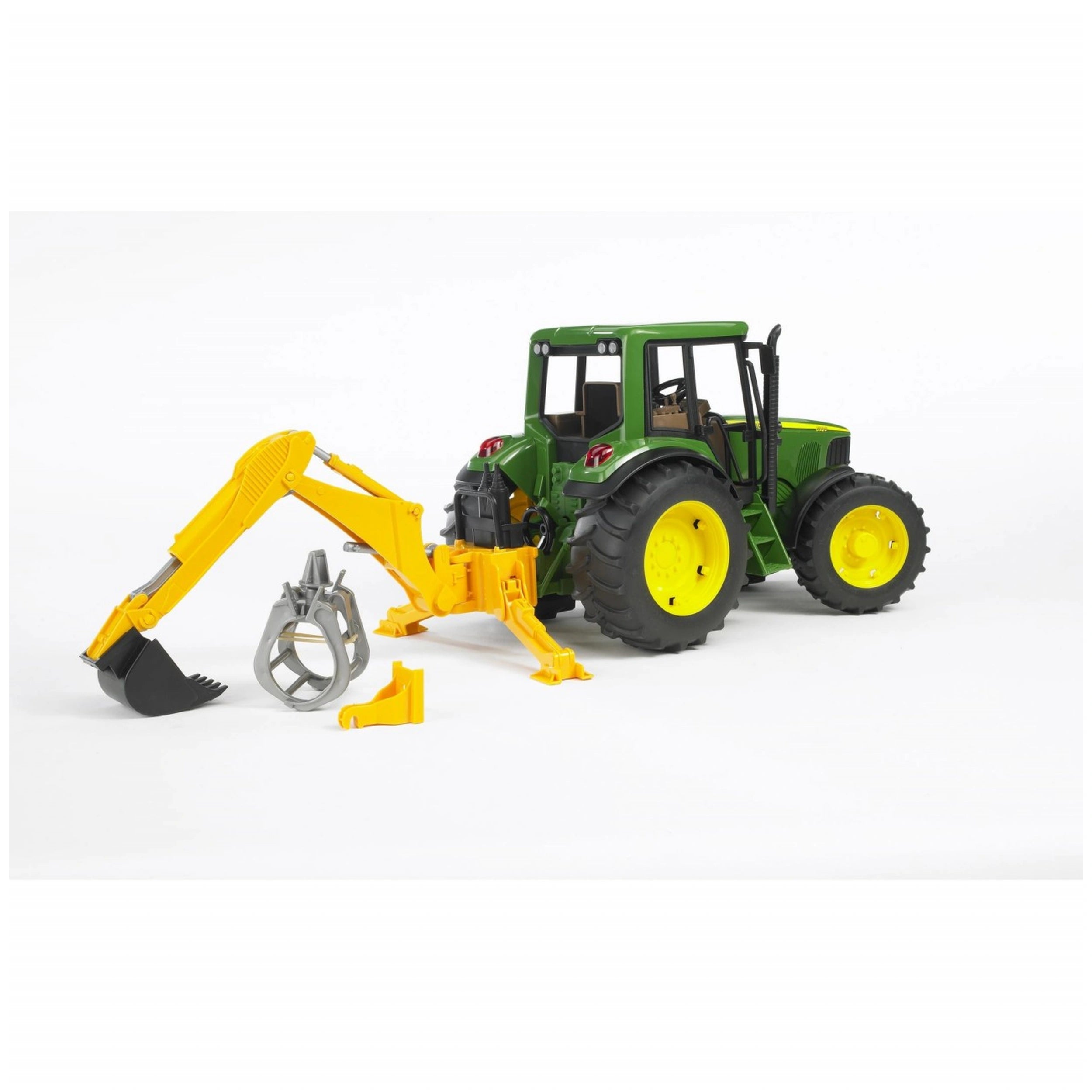Green toy tractor with yellow wheels and a rear hydraulic arm, featuring a detachable digger and grabber, on a white background.