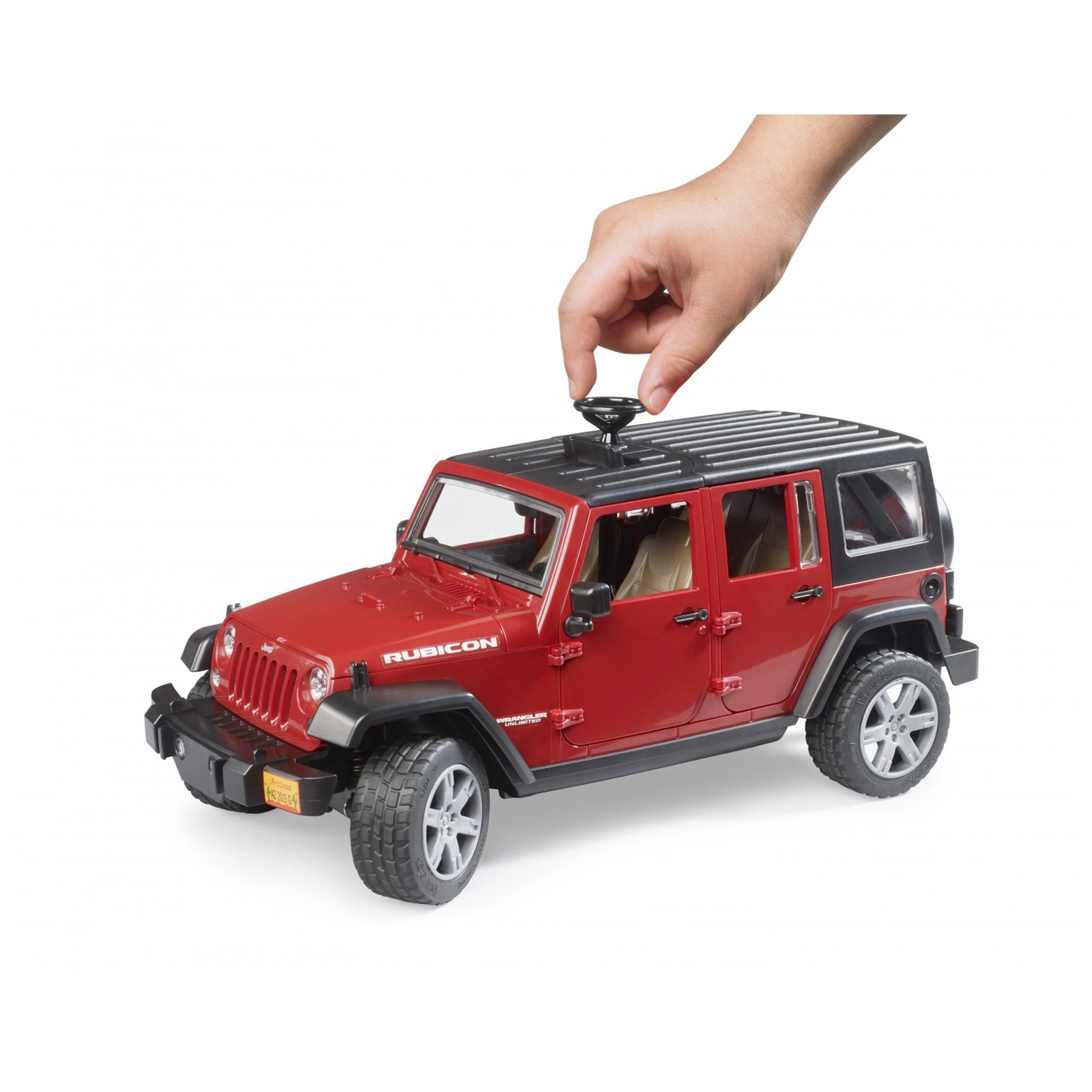 Red Bruder Jeep Wrangler Rubicon toy with hand turning lever, showing black roof, doors, and rugged tires.