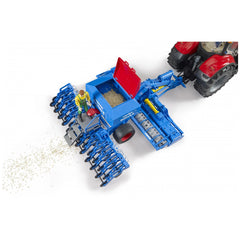 Bruder Lemken Solitair 9 toy in blue with a red lid, seed detail, and a farmer figure near a red tractor.