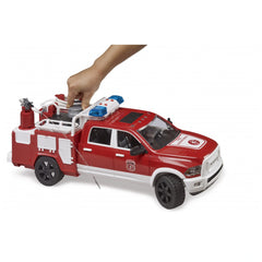 Red Bruder RAM 2500 toy fire truck with water cannon, hand operating tank, blue light on top, detailed cab.