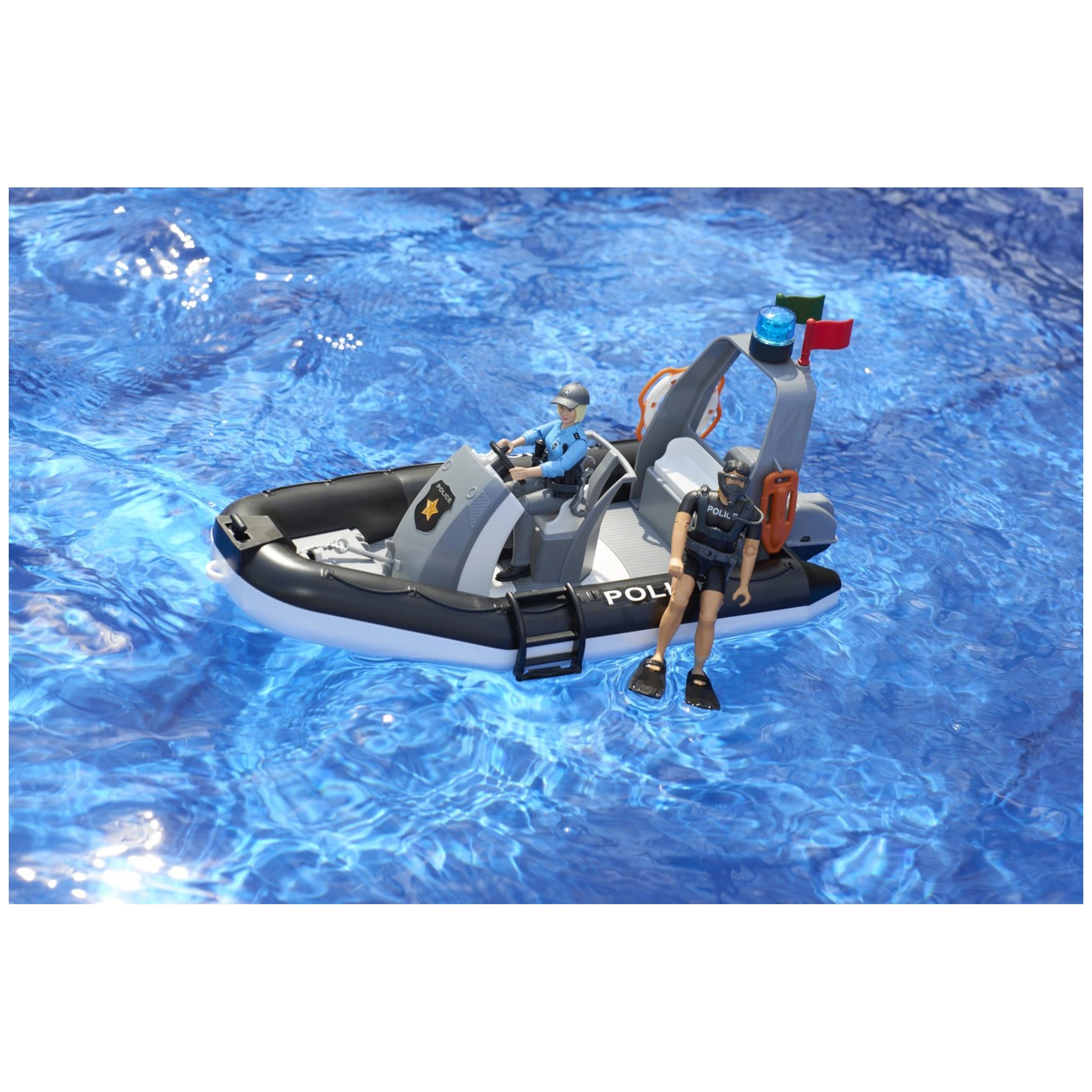 Toy police boat with two officers on a bright blue water surface, one steering, the other seated.