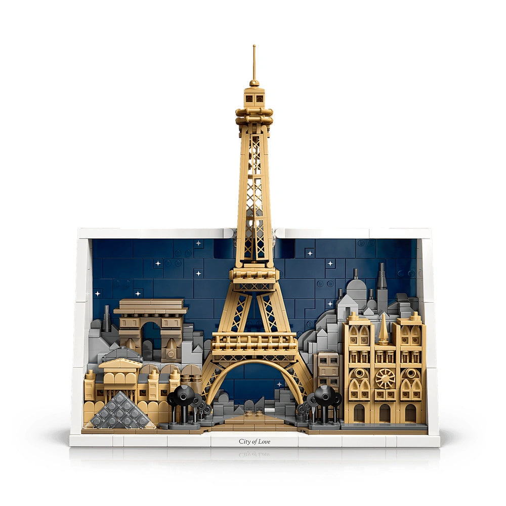 LEGO model of the Eiffel Tower surrounded by Parisian buildings, a bridge, and small figures, set against a blue sky.