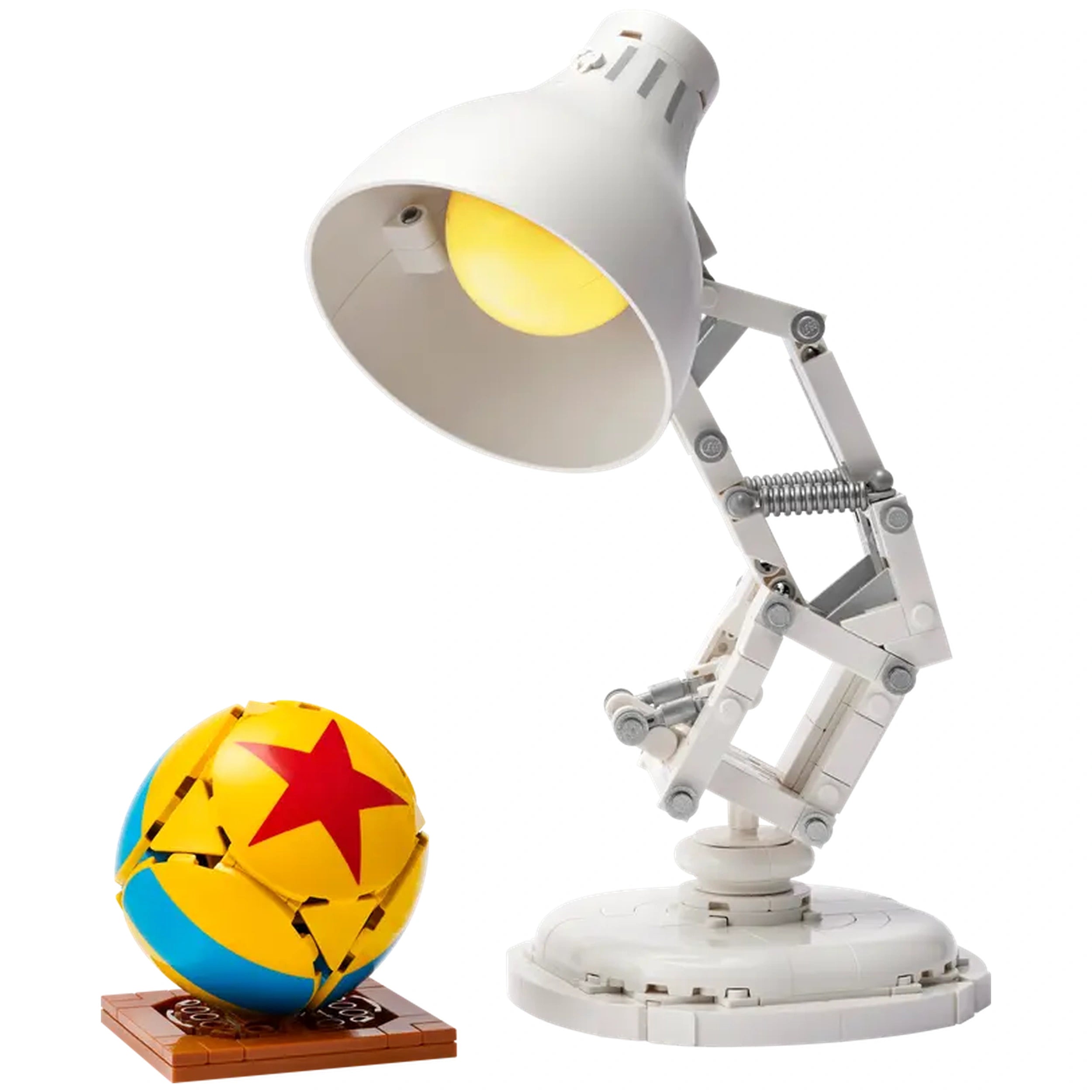 LEGO model of Luxo Jr. lamp with a yellow bulb and articulated arm beside a colorful Pixar ball on a brown base.
