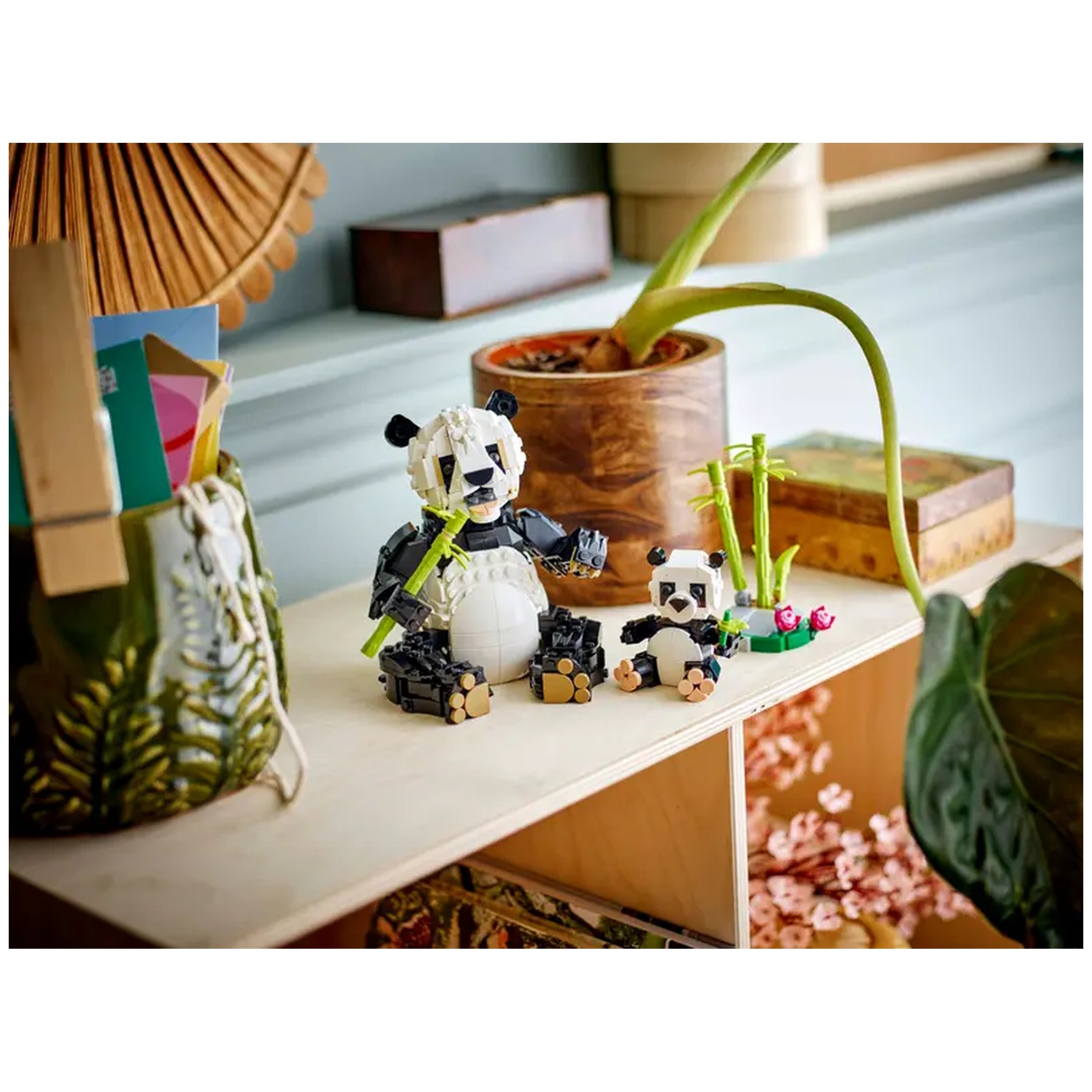 A playful LEGO Creator Panda Family set featuring a posable adult panda and a small baby panda, both surrounded by bamboo.
