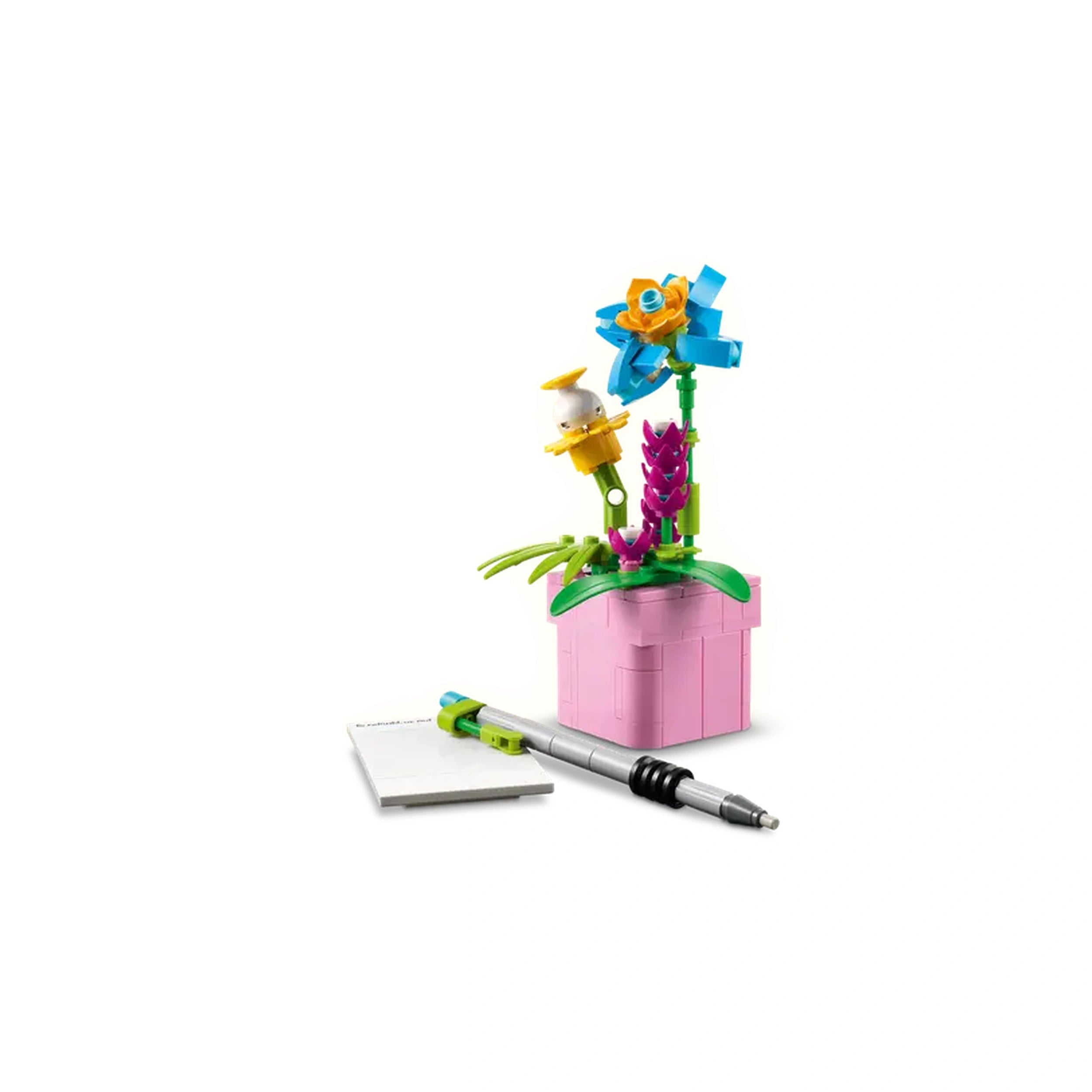 Colorful LEGO® flowers in a pink pot, featuring blue, yellow, and purple blooms, alongside a white sheet of paper and a silver pen.