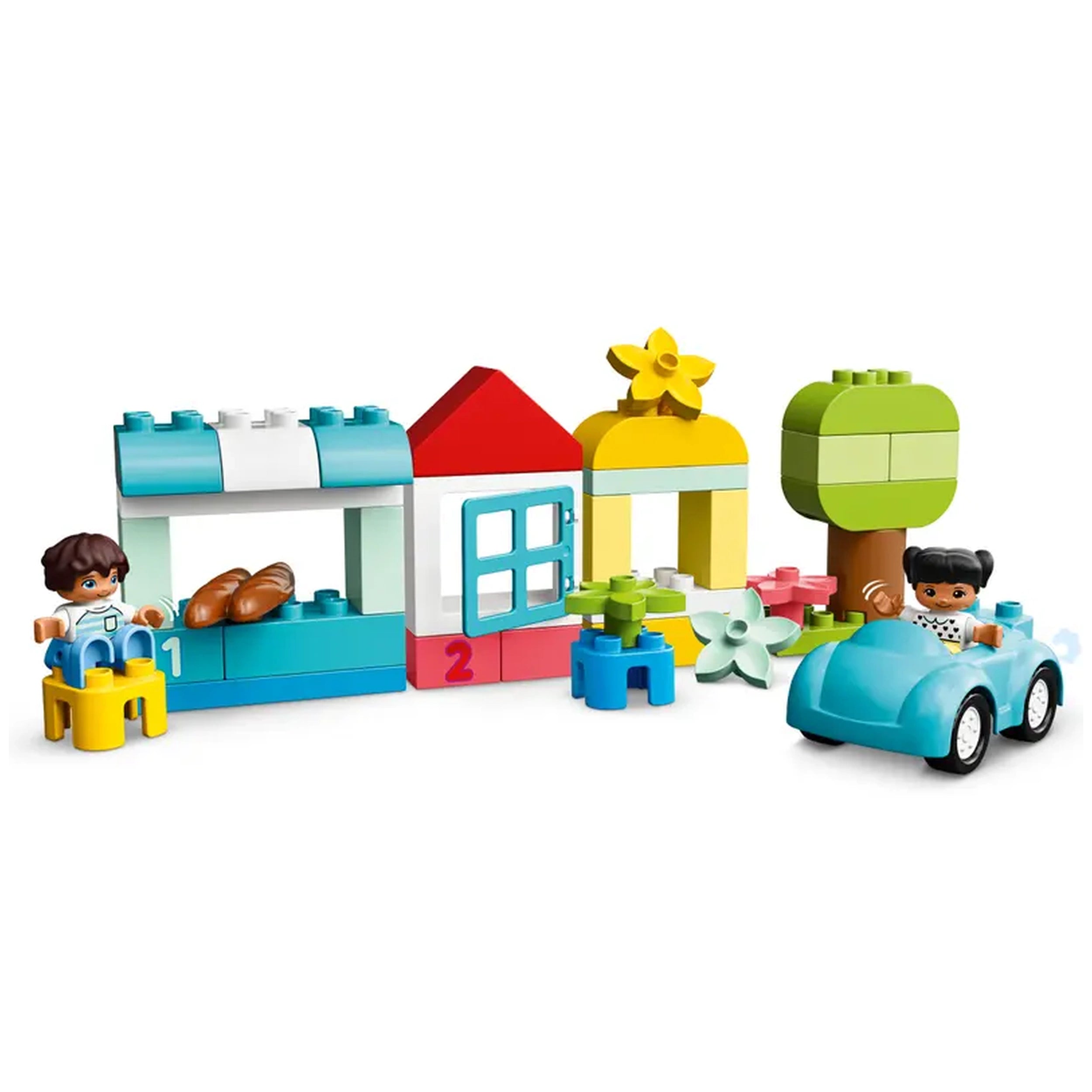 Colorful LEGO® DUPLO® construction set featuring a blue market stall, a red house, a yellow gazebo, a green tree, and two figures playing with a blue car.