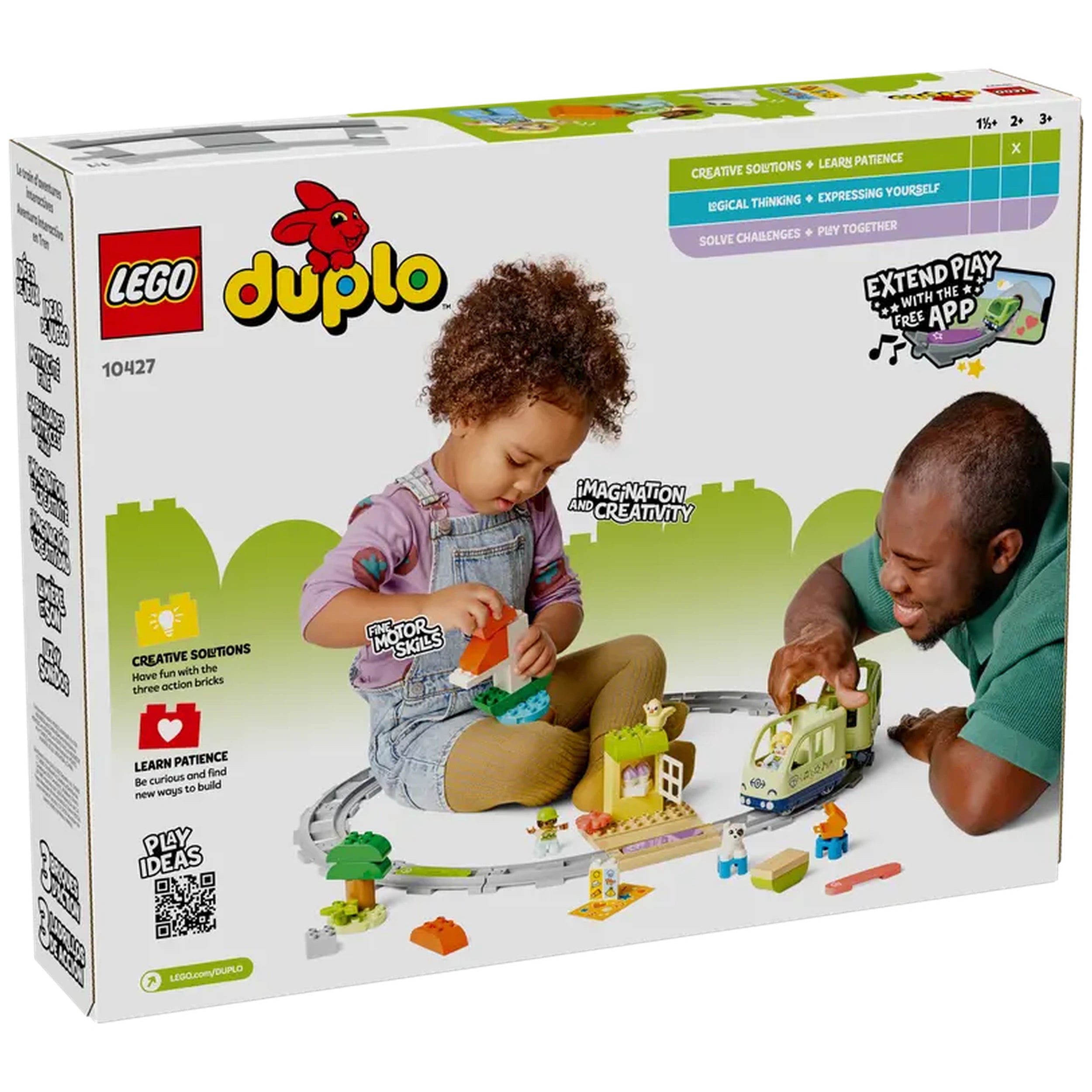 A young child with curly hair plays with colorful LEGO® DUPLO® bricks, building a scene with a train and figures, while an adult engages happily beside them.