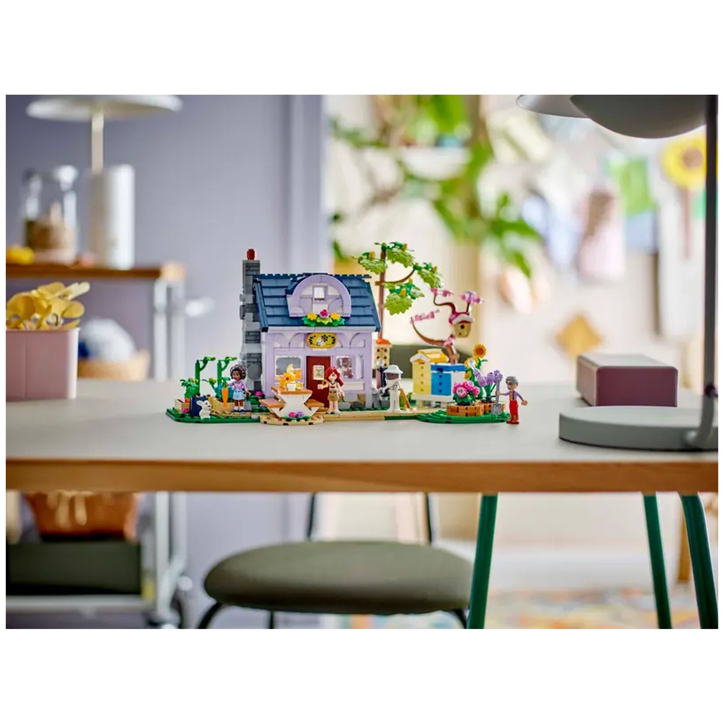 LEGO Friends Beekeepers' House and Flower Garden set, featuring a two-story house, vibrant garden, and four minidolls, displayed on a table.