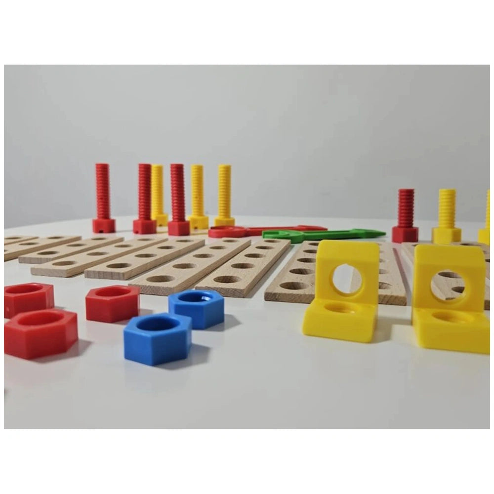 Wooden planks with holes, colorful plastic screws, and connectors laid out, part of a construction set for kids.