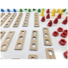 Wooden planks with holes, surrounded by colorful red, green, yellow, and blue plastic screws and connectors on a white surface.