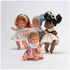 Four ASI Dolls in flower dresses and bonnets, featuring diverse hair colors and styles, seated against a white background.