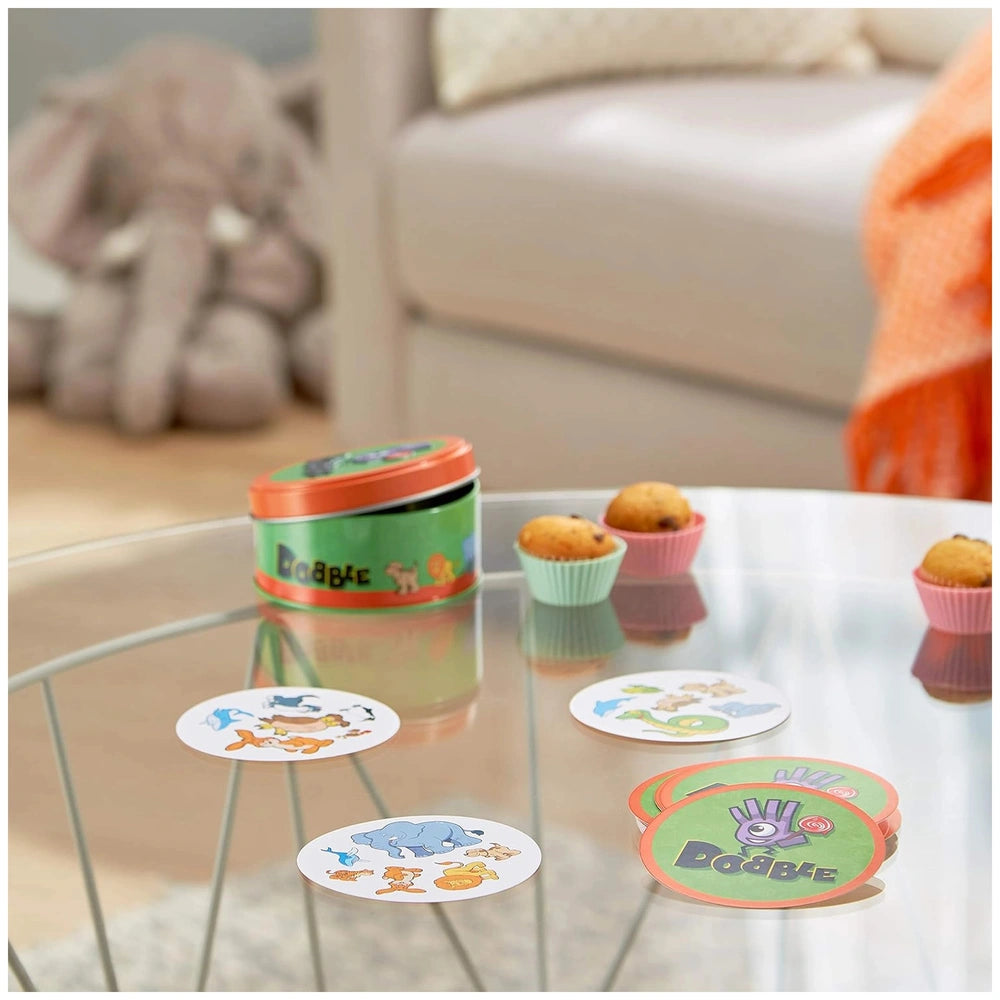 Colorful ASMODEE Dobble Kids Card Game container with coasters, enhancing children's cognitive skills in a cozy setting.